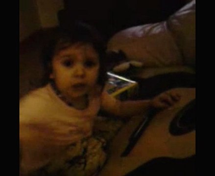 Shaïna chante et joue de la guitare