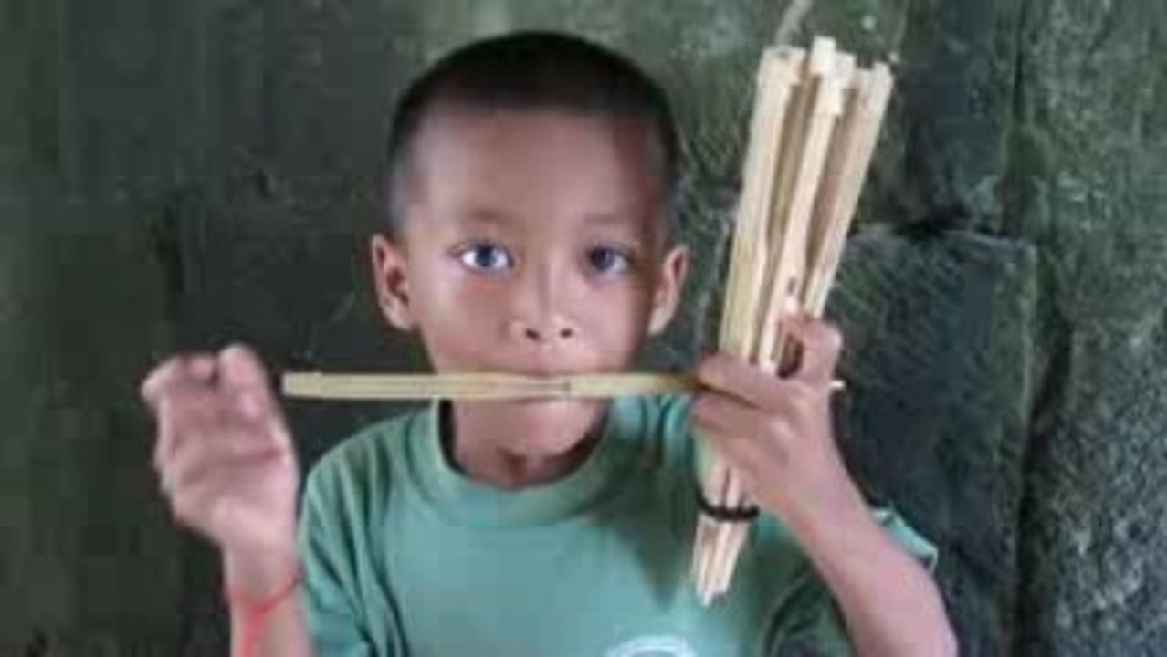 Enfant jouant de la musique dans un temple d'Angkor