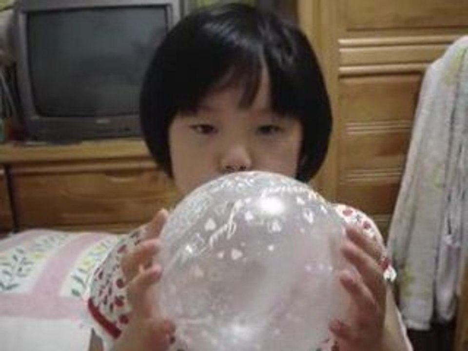 une fille gonfle un ballon