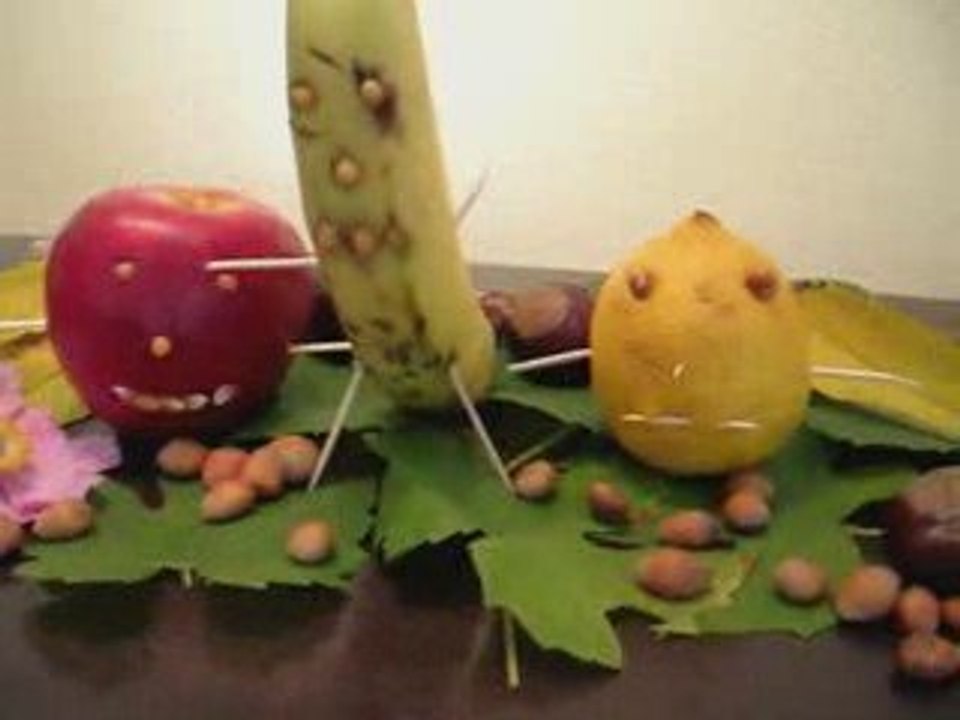 Kinder basteln eine Herbst Dekoration aus Früchten