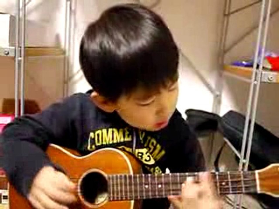 Un enfant joue une chanson de Jason Mraz au ukulele