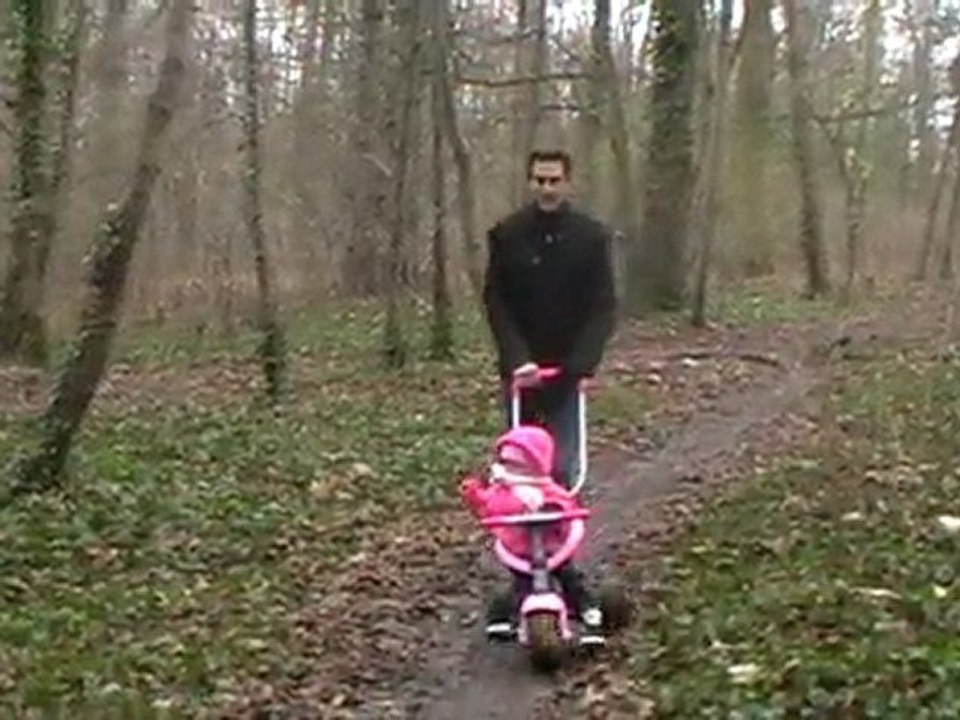 Rachel fait du tricycle dans les bois.