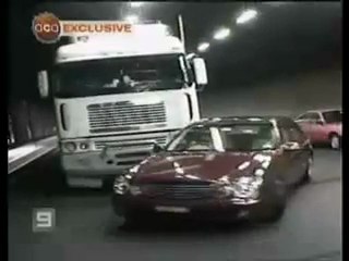 Un camion pousse une voiture dans un tunnel