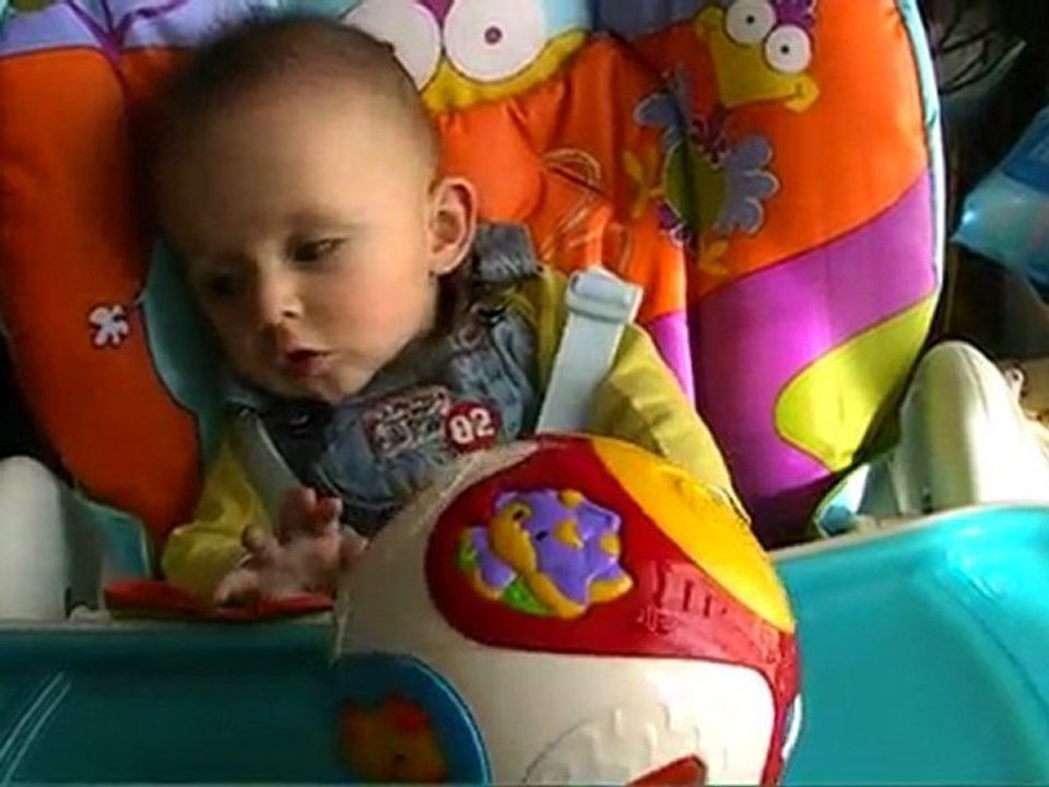 Romain joue dans sa chaise haute