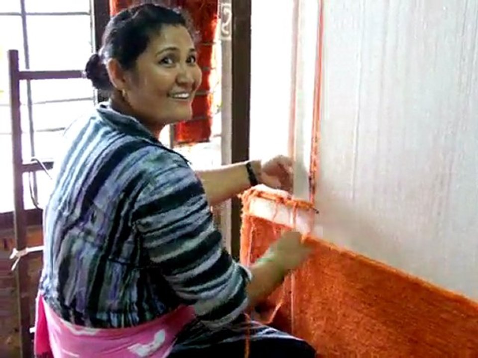 Femme travaillant dans une fabrique de tapis tibétains