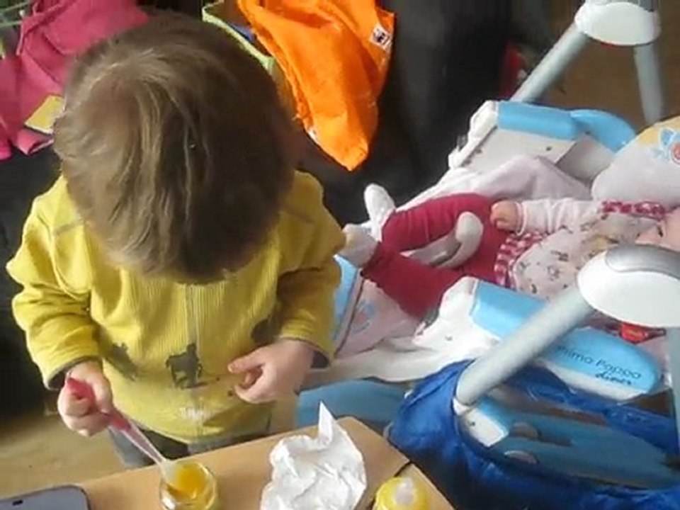 Nathanaël donne le goûter à sa petite soeur de 5mois