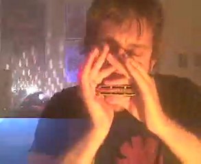 Zack plays harmonica and reads a book.