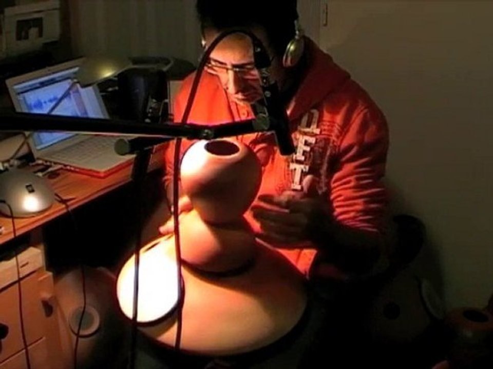 demonstration of a double udu drum with drum and bell