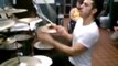 Drummer drums while juggling three drumsticks