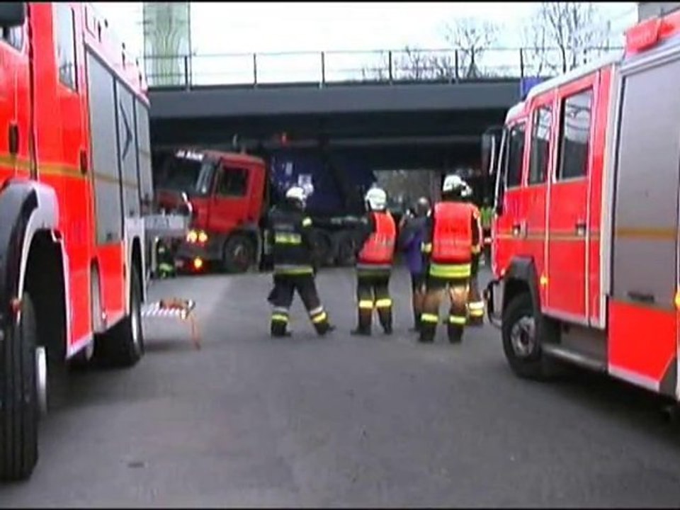 A truck gets stuck under a bridge