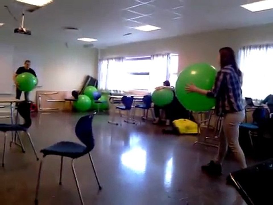 un homme lance un ballon de gym à une femme
