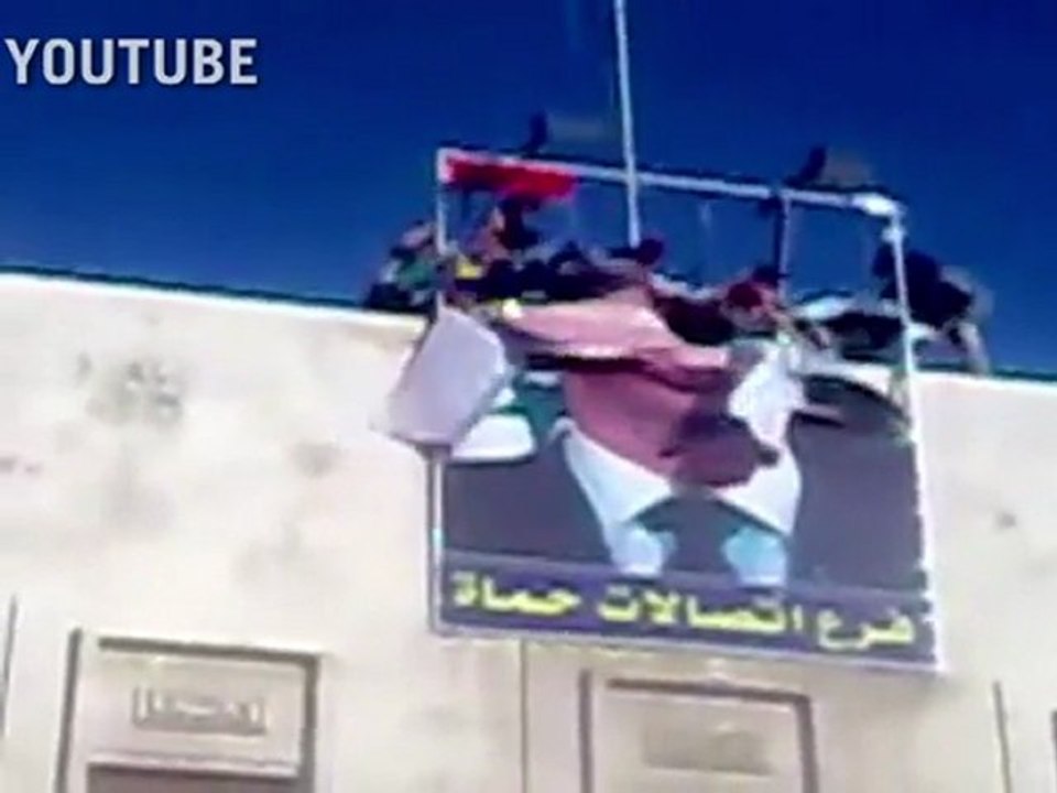 Syrian opponents tear down Assad poster in Hama