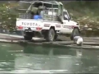 Cruzando camioneta por el rio en canoa