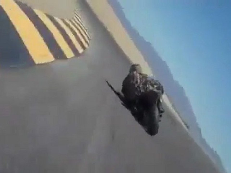 un motard touche le sol avec son casque