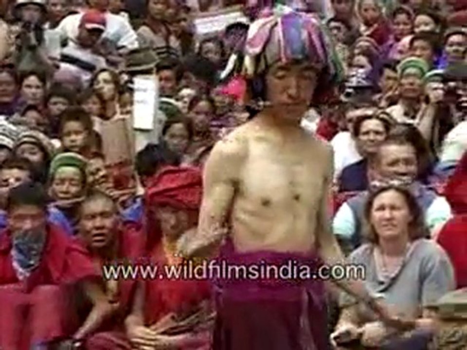 A monk piercing his cheek