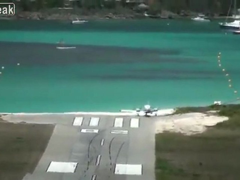 Twin-Propeller Flugzeug schießt über Landebahn am Meer