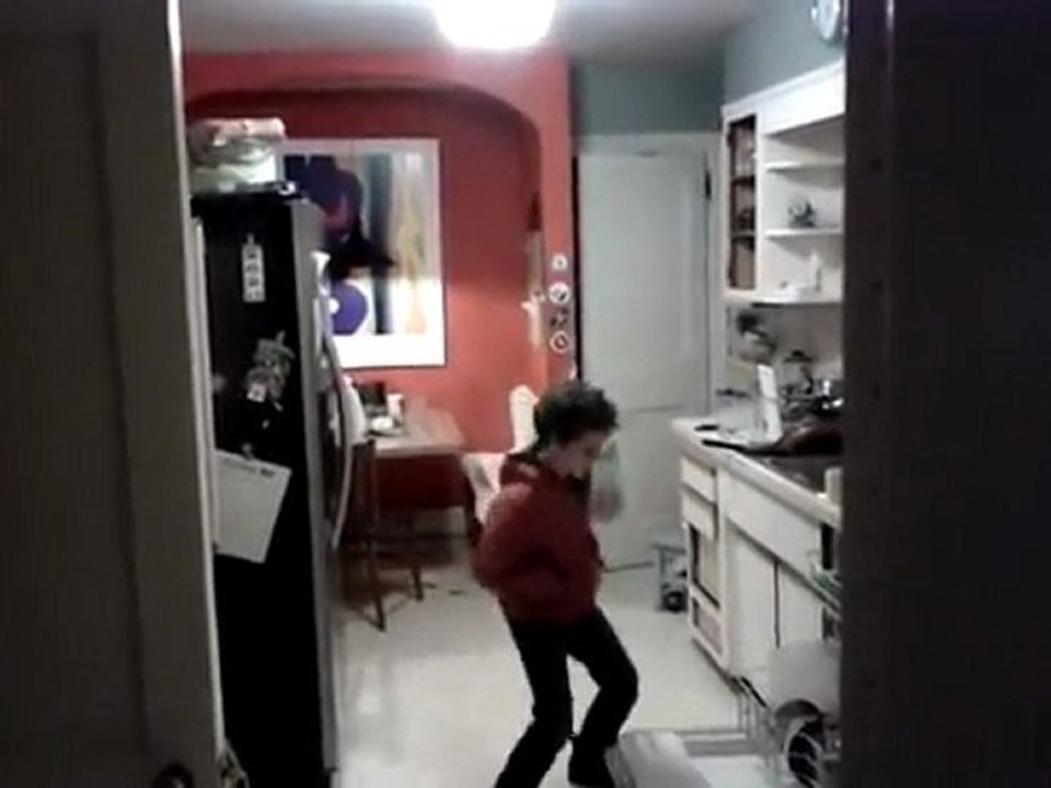 un enfant danse devant le lave vaisselle