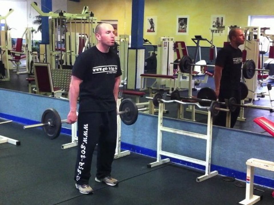 Muskelübung für den Nacken - Schulterheben mit Langhantel (hinter dem Körper)