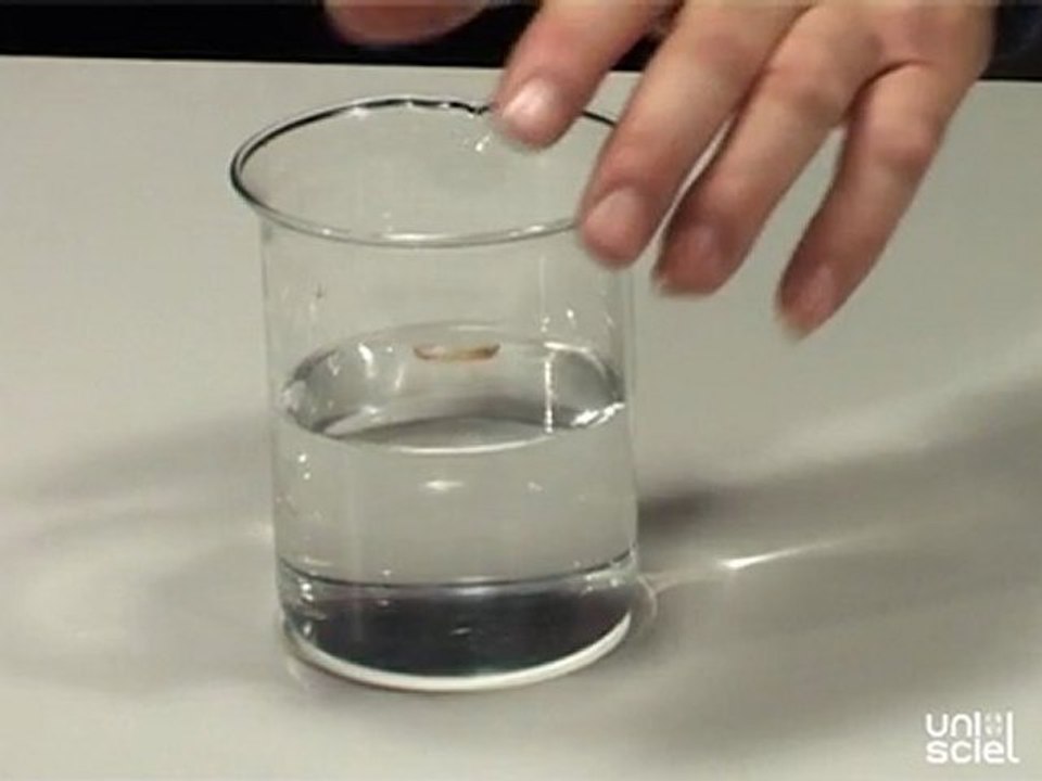 Une pièce de monnaie disparaît sous un verre