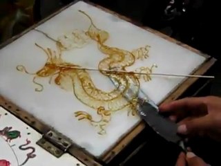 Il fait une sucette de caramel en forme de dragon
