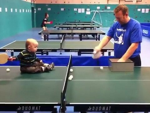 un bébé joue au ping-pong