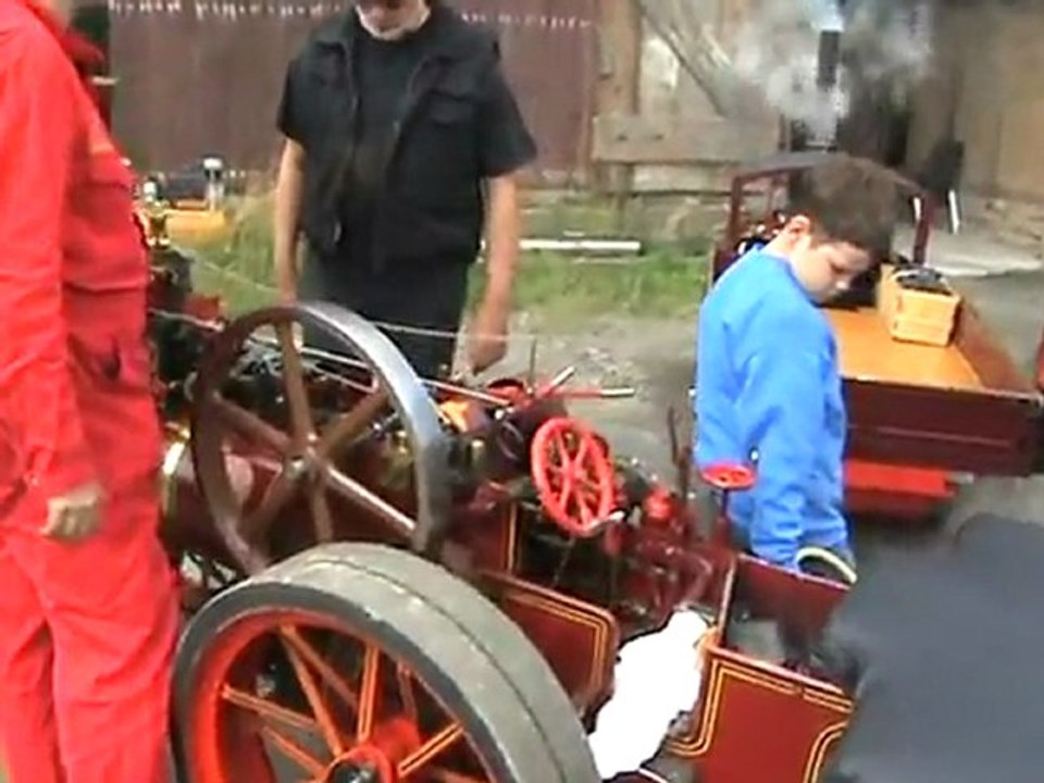Lokomobil mit altertümlichen Wohnwagen und Bowlerhut-Besatzung