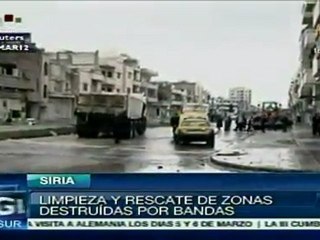 Ciudadanos intentan limpiar huellas de violencia en Homs