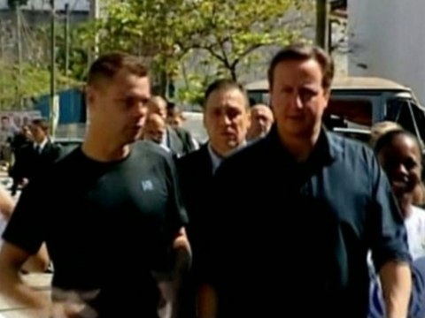 British PM Cameron walks the streets of poor neighborhood in Rio de Janeiro