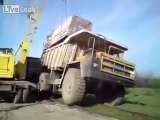 Truck topples and pulls crane down with it.
