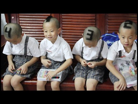 Une mère rase la tête avec des chiffres sur la tête de ses garçons quadruplet
