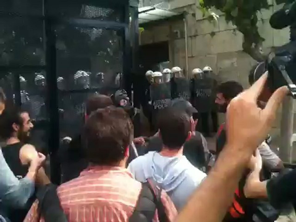 Συγκεντρωμένοι διαδηλωτές φωνάζουν συνθήματα μπροστά στον φράχτη