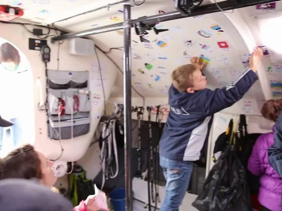 Tanguy colle les dessins envoyés par les enfants dans son bateau.