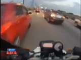 Un motard fonce entre les voitures dans un bouchon