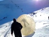 Grosse boule descend une pente de neige