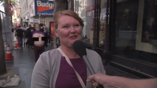 Pedestre exibe seios durante reportagem de TV