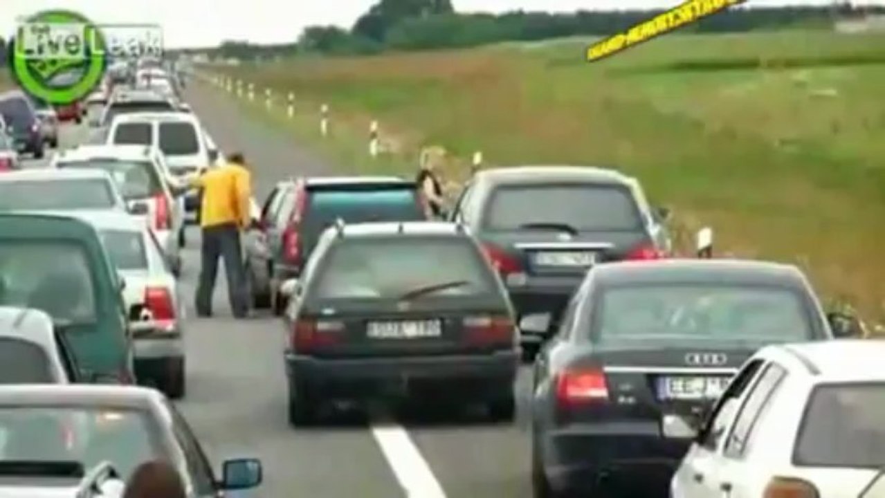 Une femme sort de son 4x4 armée d'une béquille