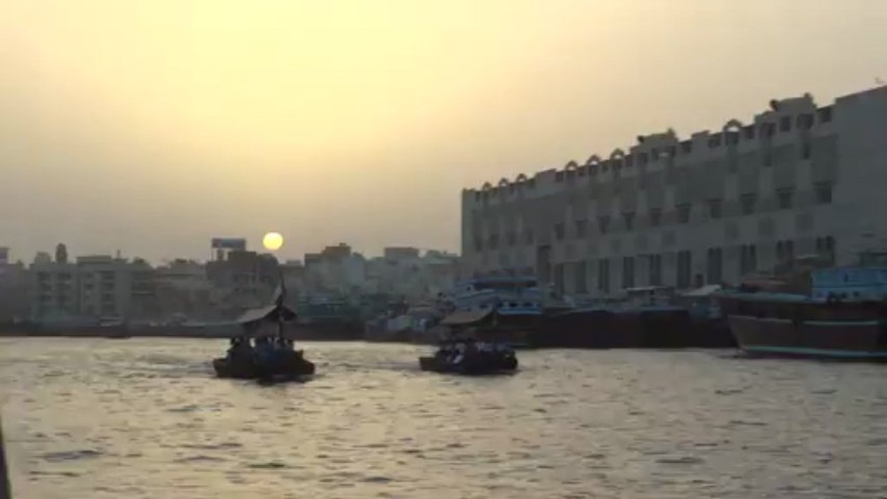 Sunset sea boats buildings Dhow cruising Deira in Dubai 13 april 2013 UAE
