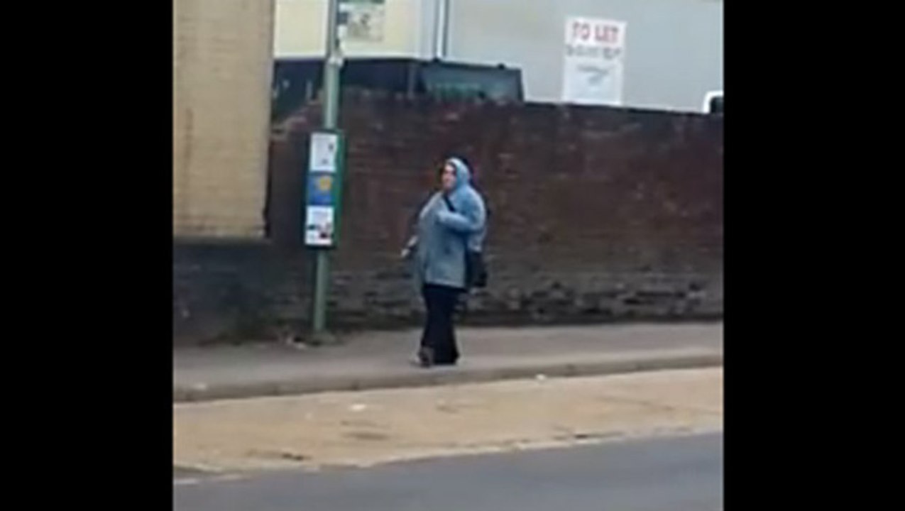 Femme danse à l'arrêt de bus