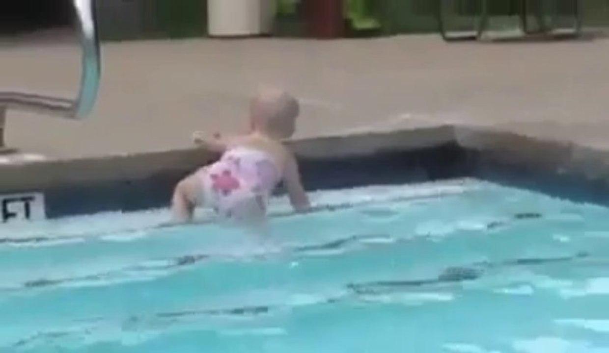 Un bébé nage dans l'eau d'une piscine