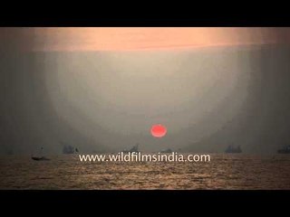 Time lapse, big crimson ball slowly dips into the Arabian Sea