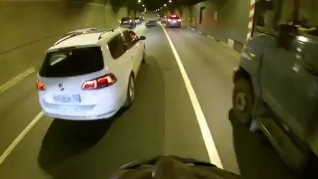 En vélo entre les camions dans un tunnel