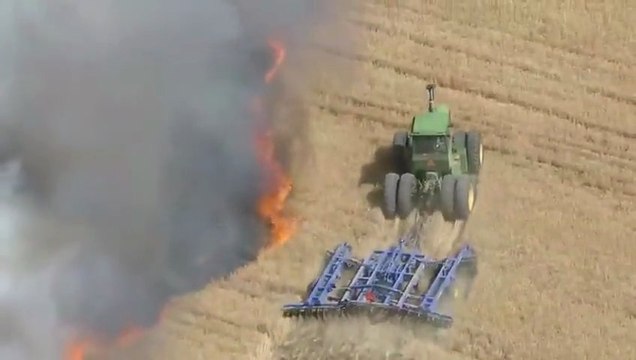 Un agriculteur fait un coupe-feu en tracteur