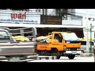 Yellow dump truck in the middle of a road - Bangkok
