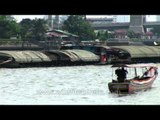 Boats dragging a cargo barge on the Chao Phraya River in Bangkok
