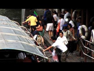A passing canal boat docked to receive more passengers in Bangkok