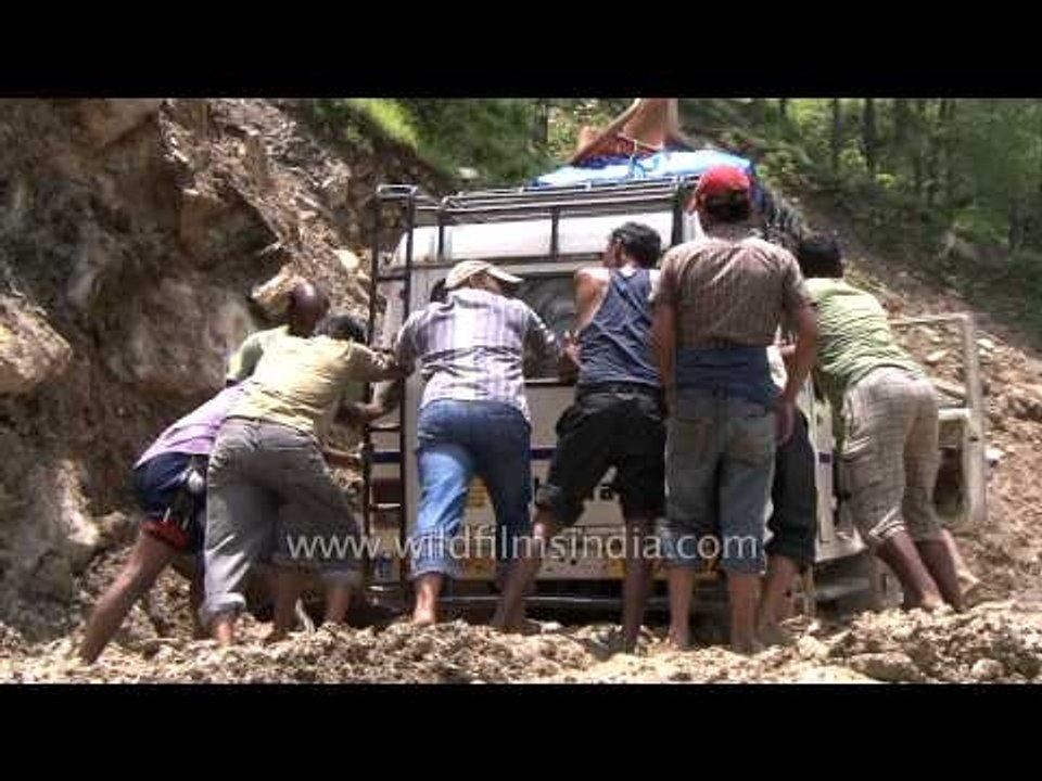 People helping take out a car stuck in Agastyamuni
