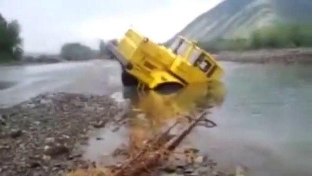 Russian tractor driver refuses to give up after his vehicle gets stuck in a river - Caterpillar Truck
