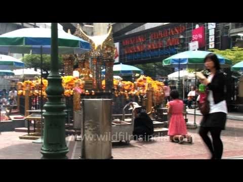 People light candles before praying at the Erawan Shrine in Bangkok