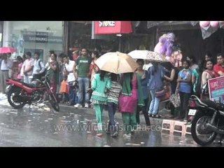 Youngsters with umbrella walking in the street in a rainy day in Uttarakhand