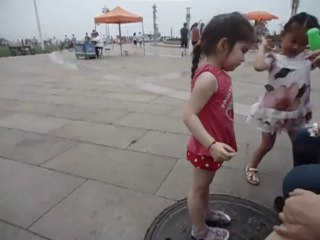 Meïline fait des bulles sur la place de la statue du vent à Qingdao